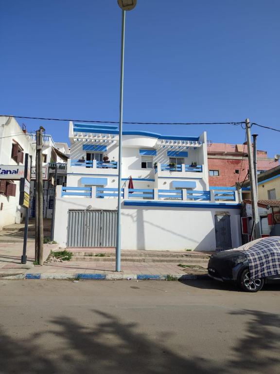 a large building with a car parked in front of it at Villa Moulay bousselham in Moulay Bousselham