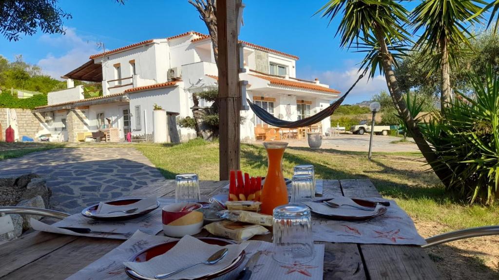 a wooden table with plates of food on top of it at Villa Rosa in Surrau in Arzachena