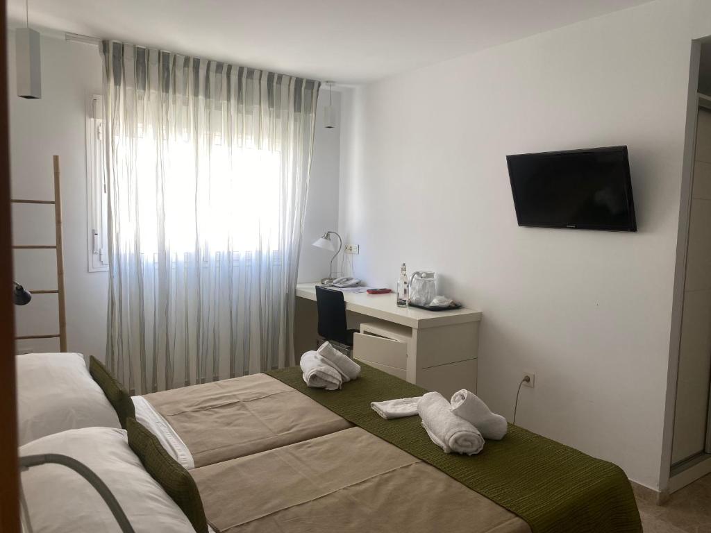 a hotel room with two towels on a bed at Hotel Senderos in Agua Amarga