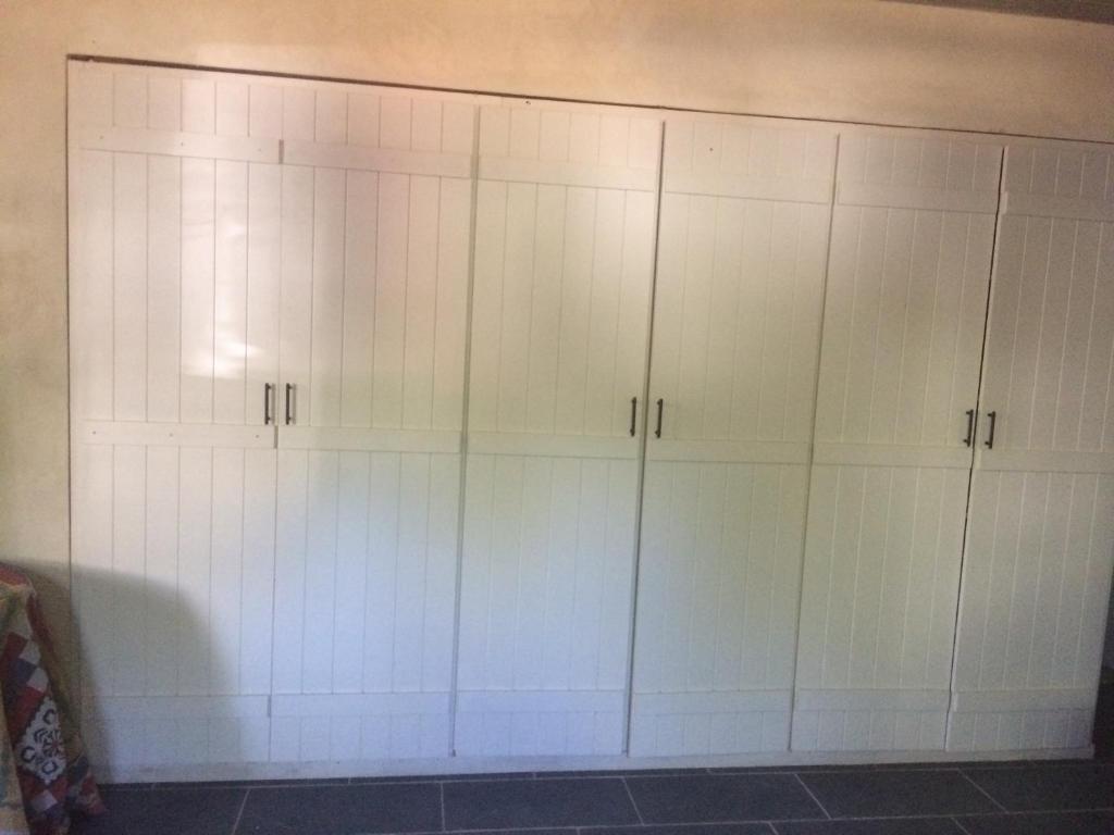 a group of white cabinets in a room at Kyparissi Guest House in Paralía Kiparissi