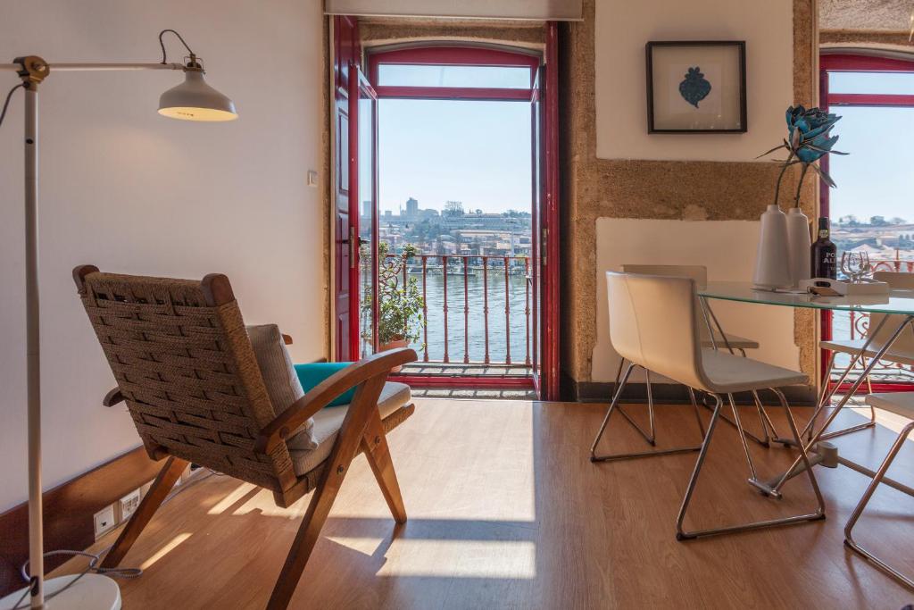 a living room with a table and chairs and a balcony at Go2oporto - Ribeira do Porto in Porto