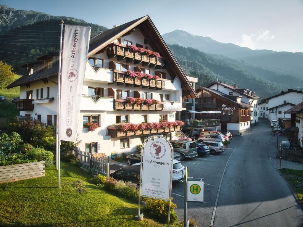 un grand bâtiment avec un panneau devant lui dans l'établissement Hotel die Arlbergerin ADULTS FRIENDLY 4 STAR, à Sankt Anton am Arlberg