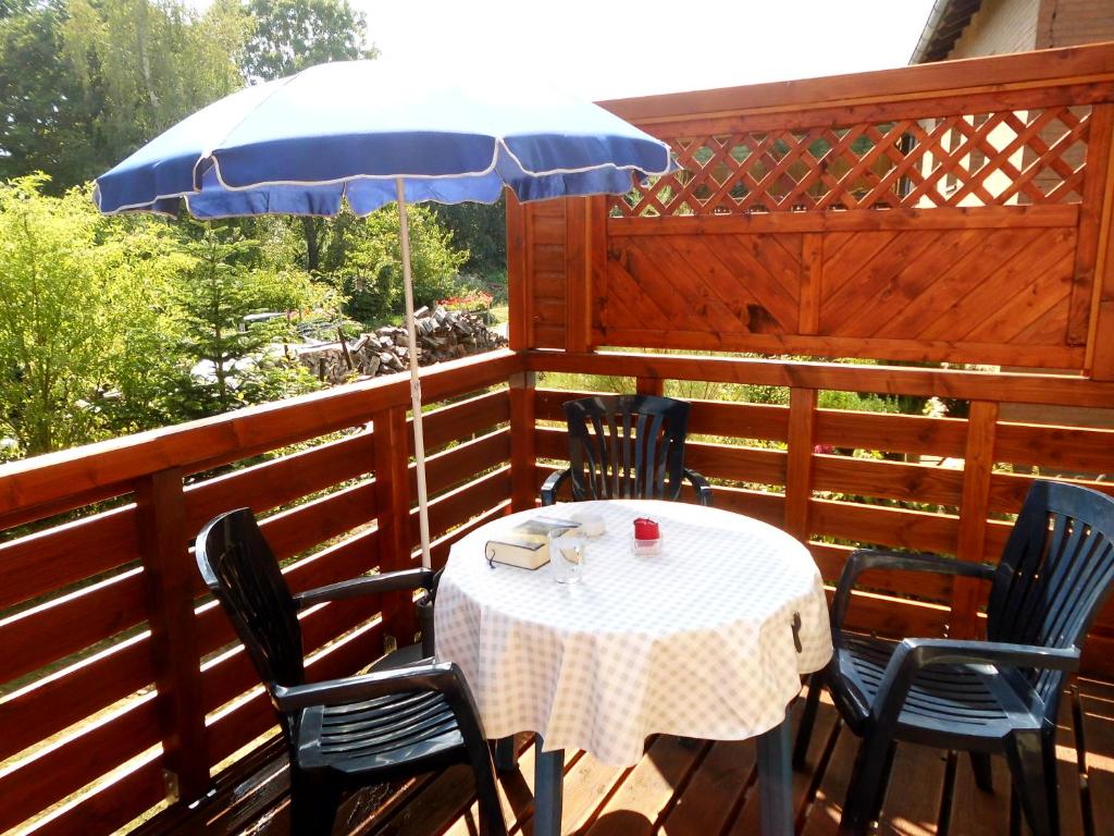 einen Tisch und Stühle mit einem Sonnenschirm auf einer Terrasse in der Unterkunft Haus Abel in Aerzen