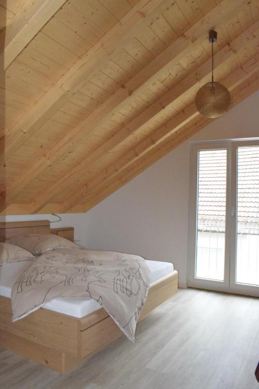 um quarto com uma cama e um tecto de madeira em Sauers Schwarzwaldglück em Appenweier