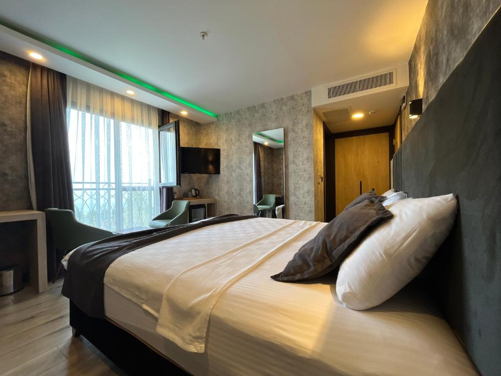 1 dormitorio con 1 cama grande en una habitación en Avni Bey Otel, en Araklı