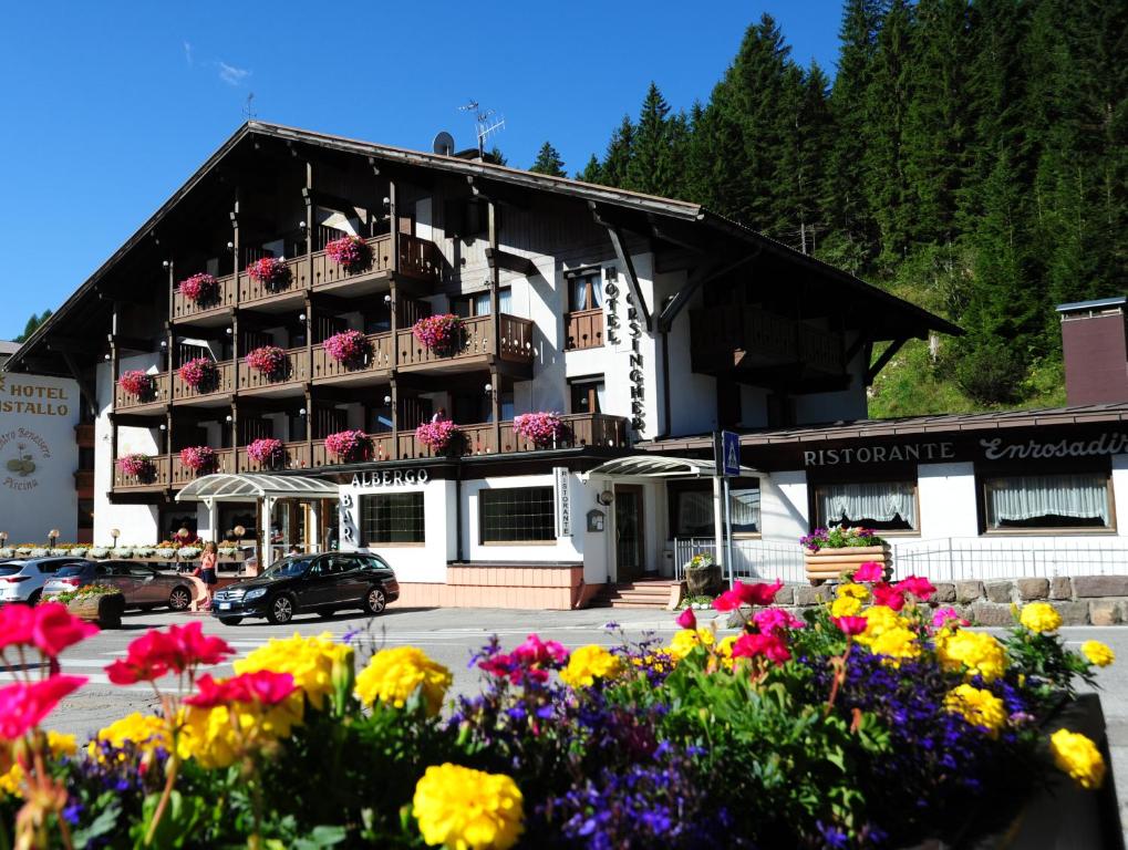a large building with flowers in front of it at Hotel Orsingher in San Martino di Castrozza