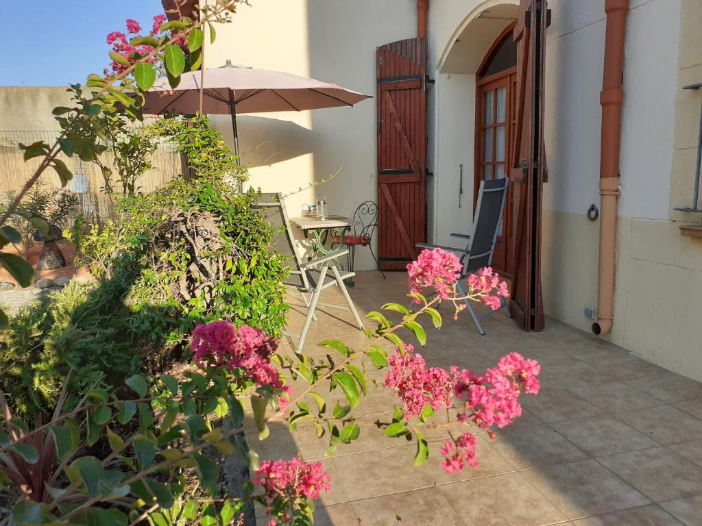 a patio with pink flowers and an umbrella at Bompastor in Bompas