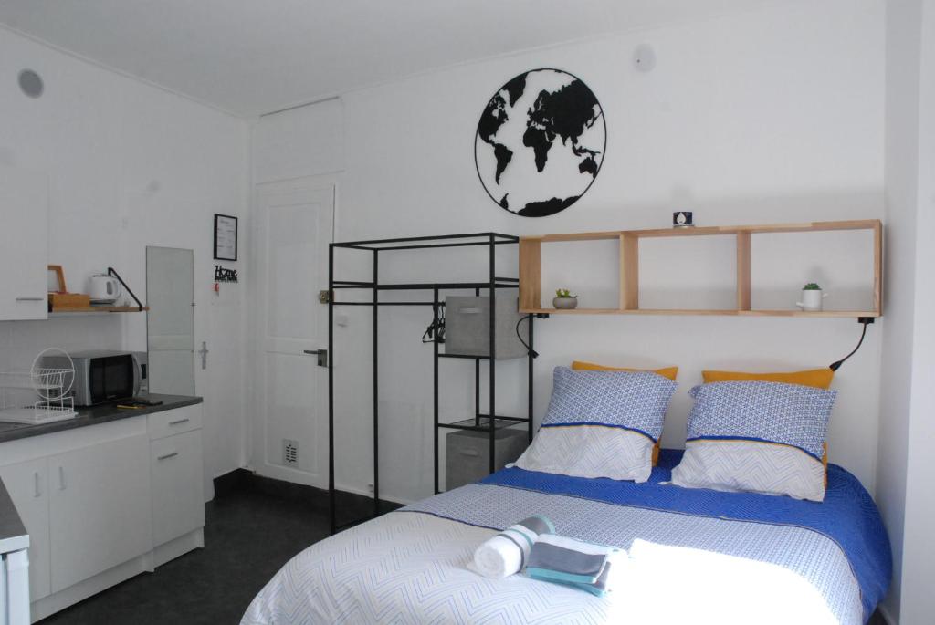 - une chambre avec un lit doté d'oreillers bleus et oranges dans l'établissement Studio Nancy quartier Thermal - Parc Sainte-Marie, à Nancy