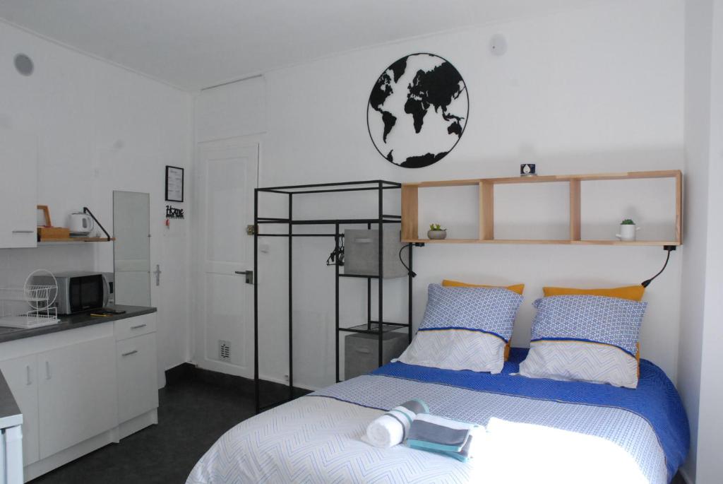 a bedroom with a bed with blue and orange pillows at Studio Nancy quartier Thermal - Parc Sainte-Marie in Nancy