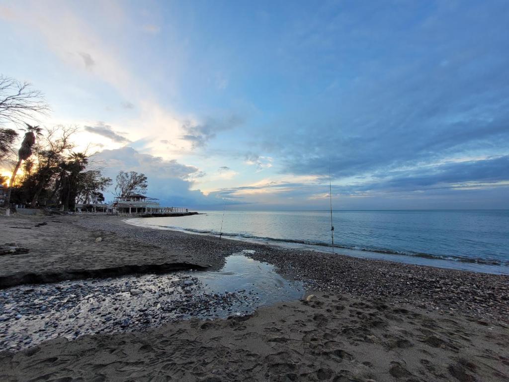 a beach with the ocean and a cloudy sky at "COZY LOFT", TERRACE, PARKING and SWIMMING POOL in Málaga