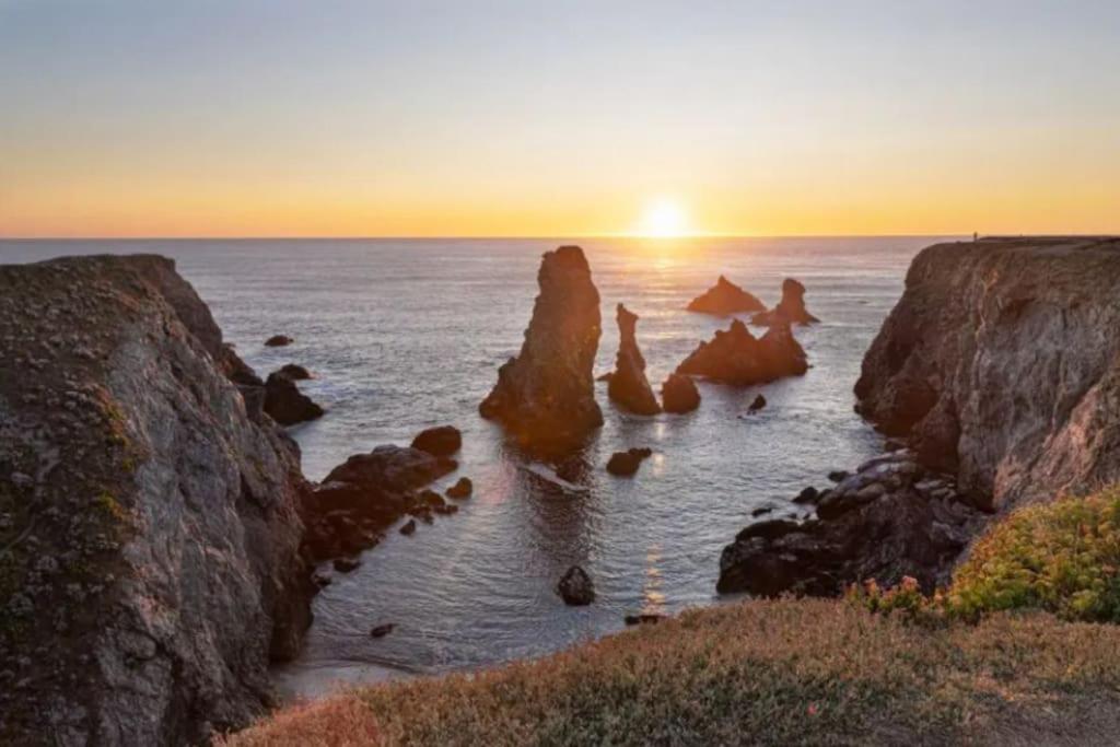 Un groupe de rochers dans l'océan au coucher du soleil dans l'établissement Maison entre Terre et Mer avec Jacuzzi, à Sauzon