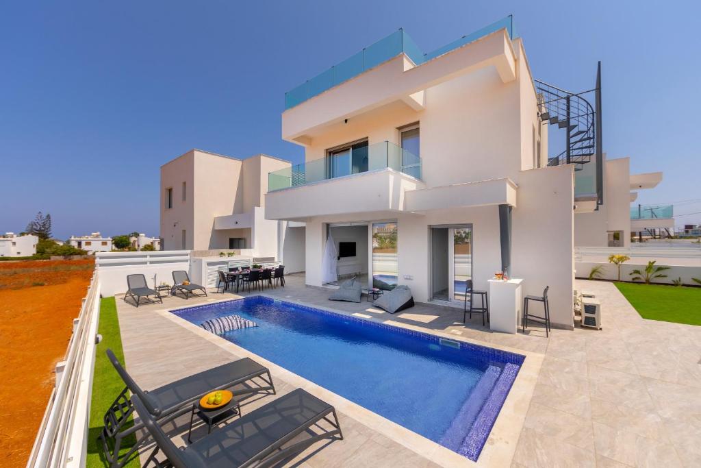 a villa with a swimming pool and a house at Protaras Sol e Mar Villa 3 in Protaras