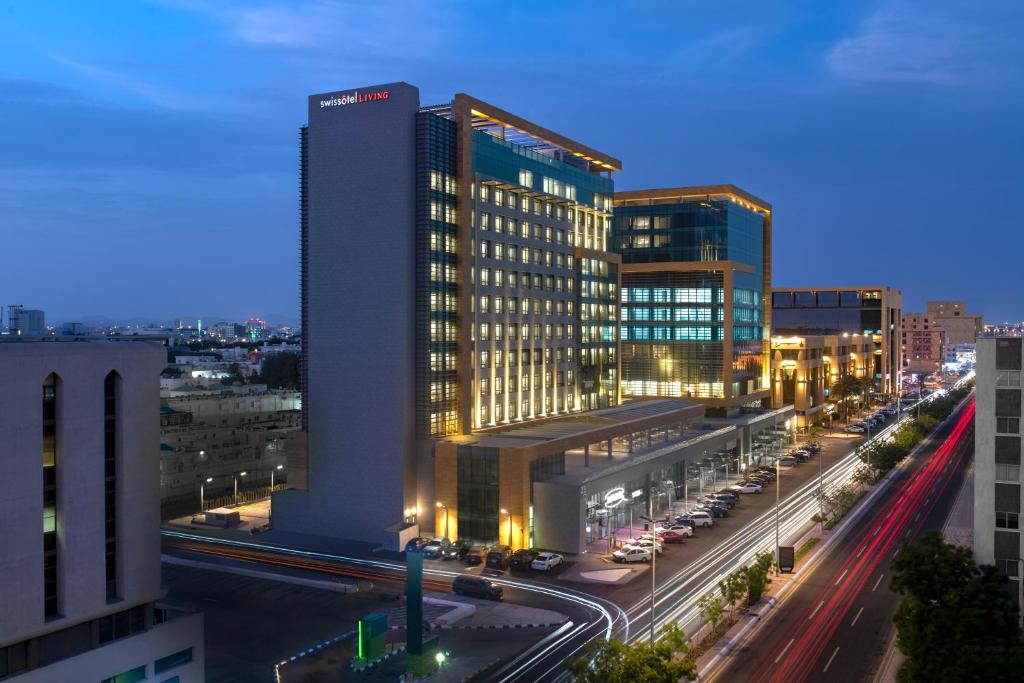 a building with lights on in a city at night at Swissotel Living Jeddah in Jeddah