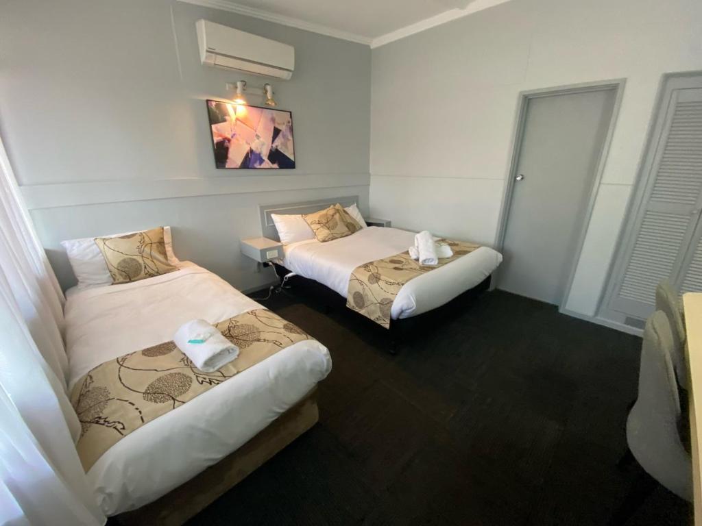 a hotel room with two beds and a window at Charlton Motel in Charlton