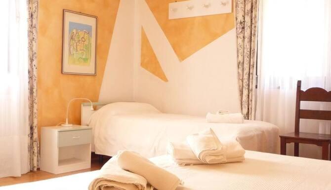 Moggio UdineseにあるLOCANDA SAN GALLOのベッド2台と窓が備わるホテルルームです。