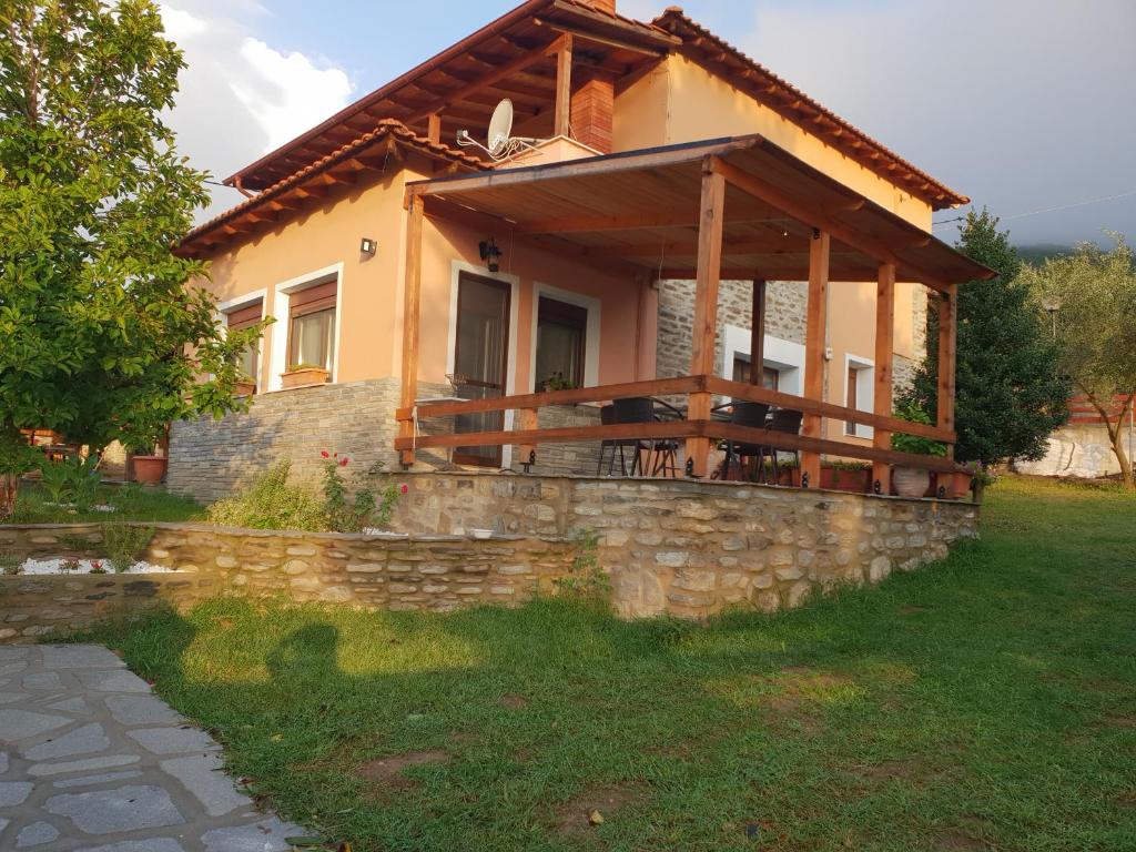 ein Haus mit einer Steinmauer und einer Veranda in der Unterkunft Mavridis House in Eleftheroúpolis