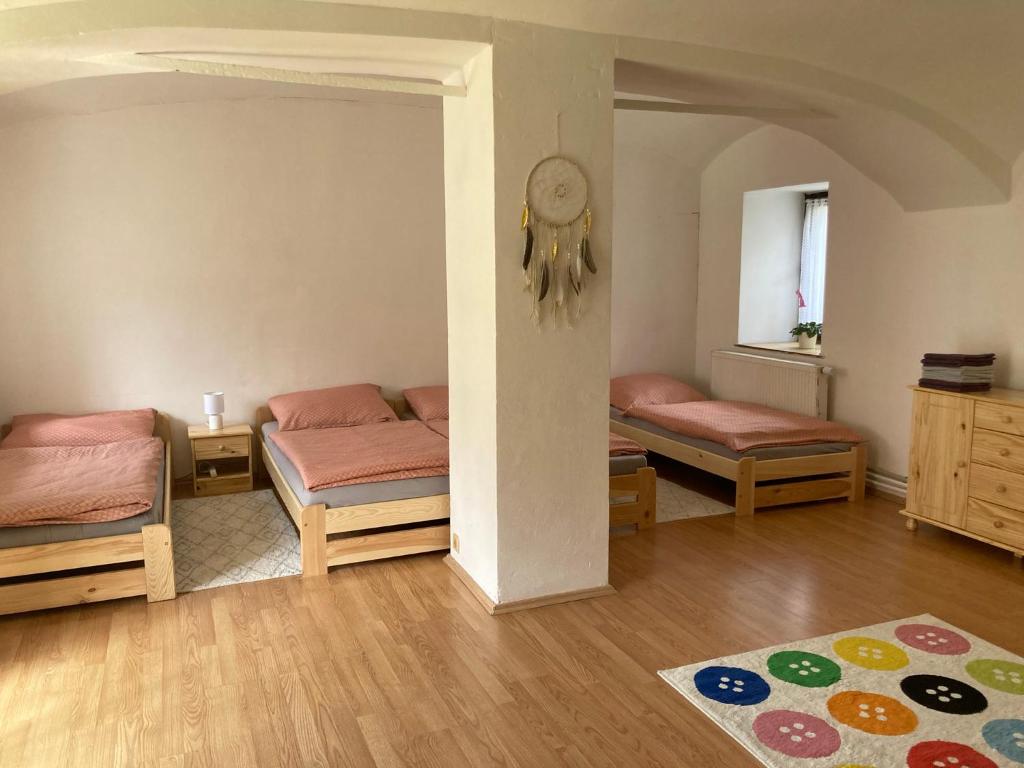 um quarto com três camas e um tapete no chão em Příjemný apartmán se zahradou em Ostřešany