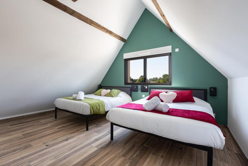- 2 lits dans une chambre aux murs verts et blancs dans l'établissement Villa gorille - 240m2- 6chb - SPA-Sauna-Babyfoot-Arcade, à Ittenheim
