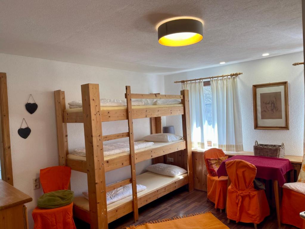 Hausen im TalにあるMurmeltierの二段ベッド1組とテーブル1台が備わる客室です。