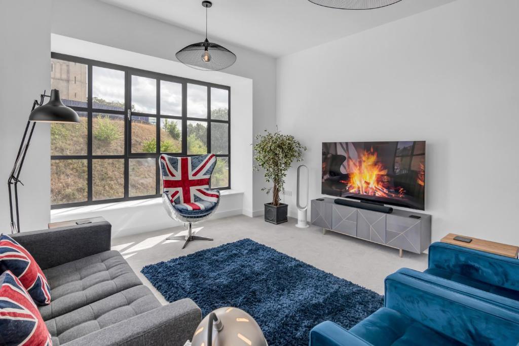 a living room with a couch and a fire in the fireplace at Norwich Castle View Apt - Modern 2 Br in Norwich