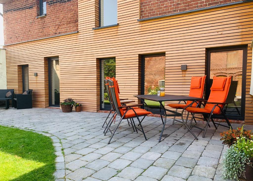 eine Terrasse mit einem Tisch und Stühlen vor einem Haus in der Unterkunft Deichgraf „Die Elbpension“ in Dornburg