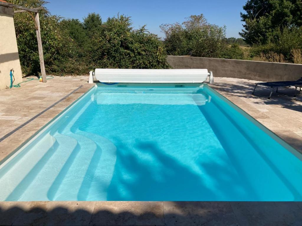 una piscina con agua azul en un patio trasero en Rustic cottage with stunning swimming pool, en Saint-Front