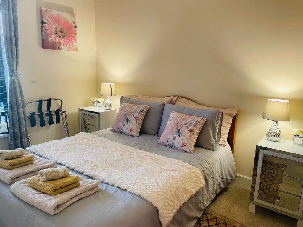 una camera da letto con un grande letto con asciugamani di A Room in Central Park Apts a Carrick on Shannon