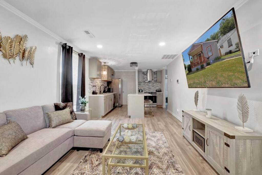 a white living room with a couch and a kitchen at Royalty in the Magic City in Birmingham