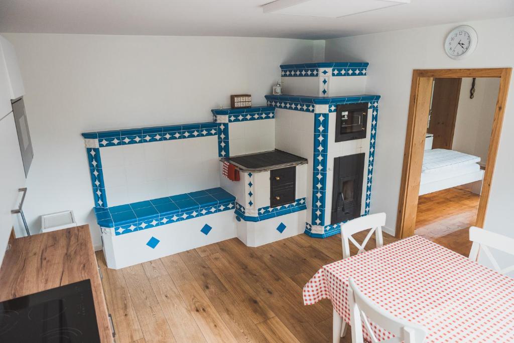 una cocina con armarios azules y blancos y una mesa. en Chalupa U lesa, en Vápenice