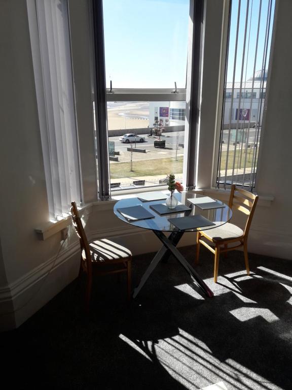 a table and two chairs in a room with a window at Southbay Holiday Flats Flat 2 in Bridlington