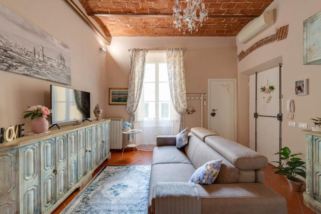 a living room with a couch and a television at eLLe Apartments Firenze in Florence