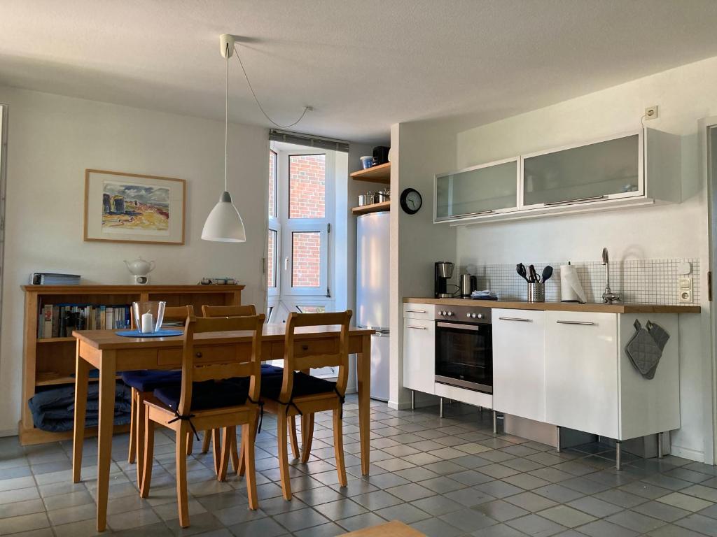 uma cozinha e sala de jantar com mesa e cadeiras em Haus Karin Wohnung 1 em Wittdün