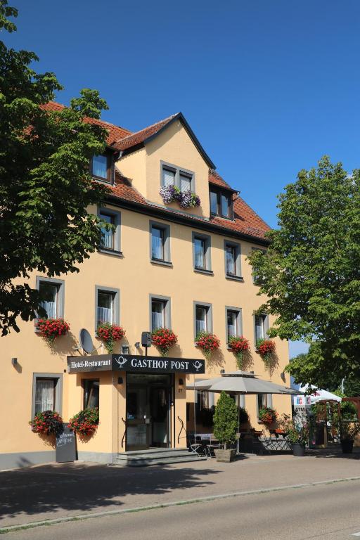 um grande edifício com uma placa em frente em Gasthof Post em Rothenburg ob der Tauber