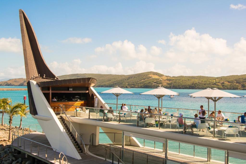 un restaurante en la playa junto al agua en Yacht Club Villas on Hamilton Island by HIHA, en Hamilton Island