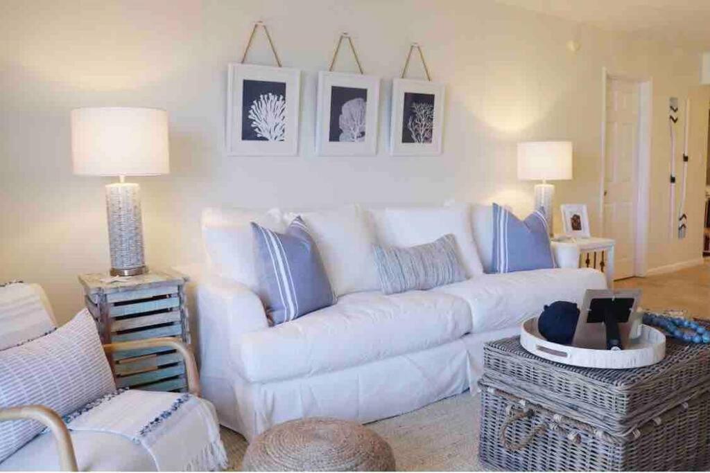 a living room with a white couch and blue accents at Your Happy Place ON THE BEACH! in Key Colony Beach