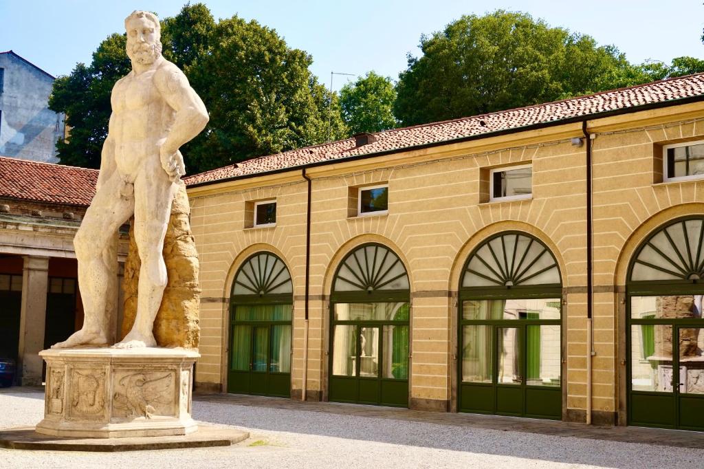 a statue of a man in front of a building at Palazzo Mantua Benavides Suites & Apartments in Padova