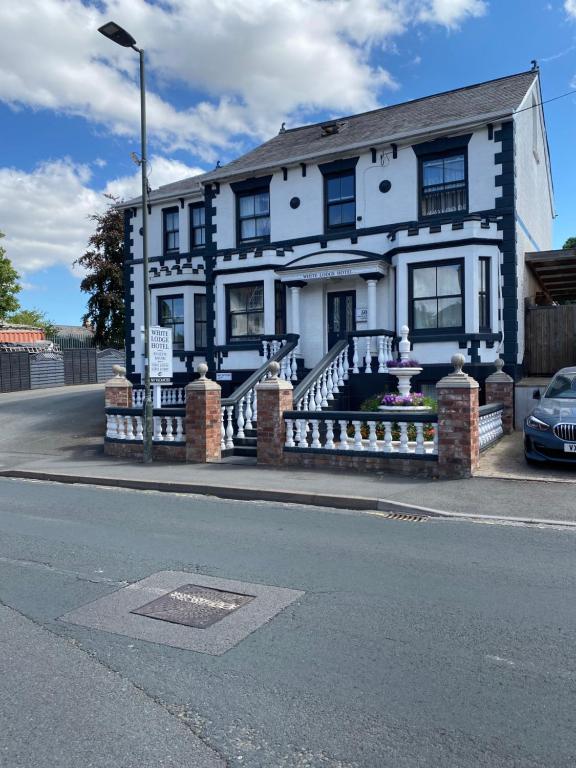 a white house with a sign in front of it at The White Lodge Hotel in Hereford