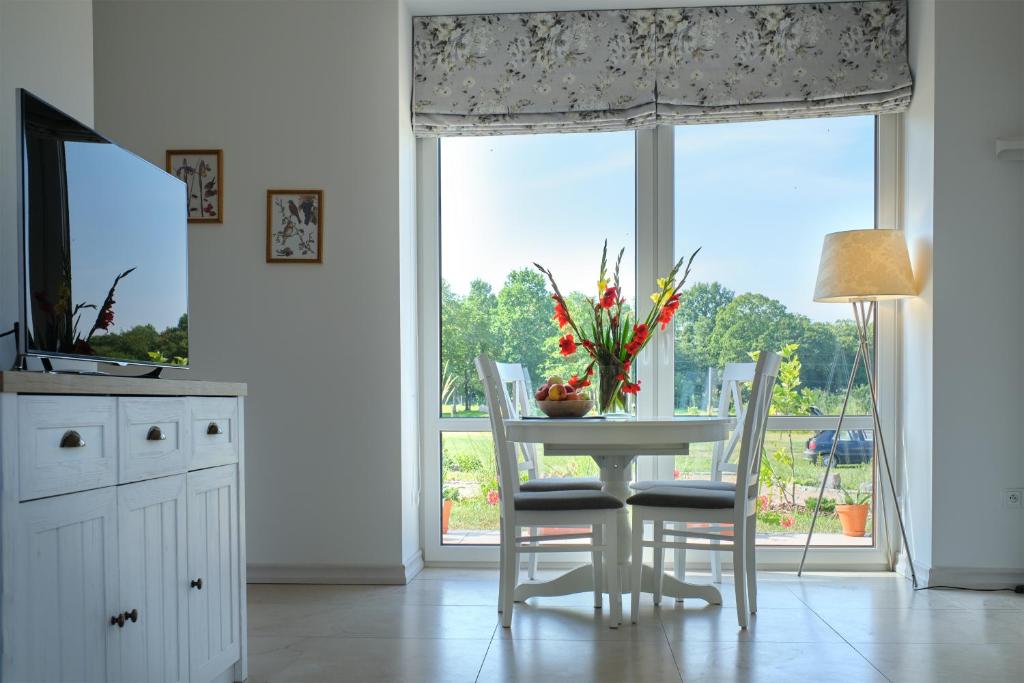 kuchnia ze stołem i krzesłami oraz oknem w obiekcie Komfortowy domek z kominkiem w mieście Barwice