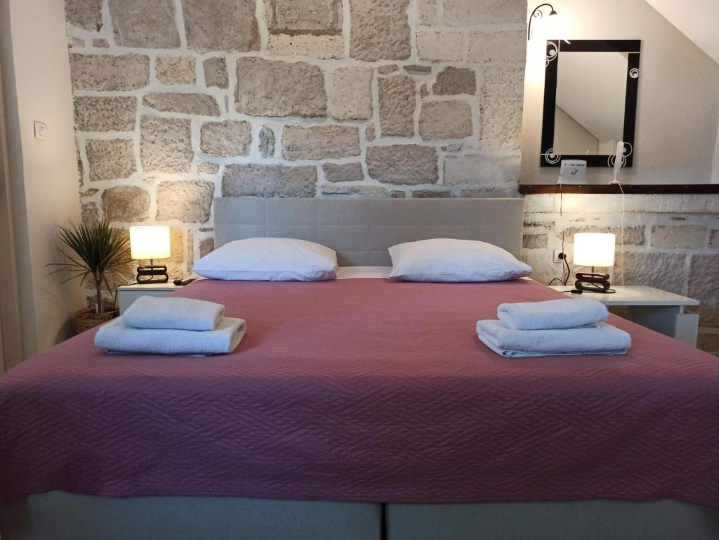 a bedroom with a large bed with two pillows at Guest House Renata1 in Zadar