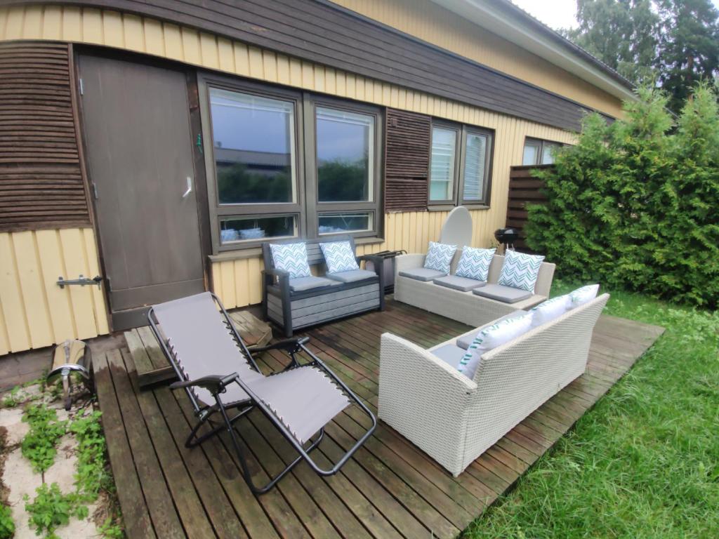eine Terrasse mit 2 Stühlen, einem Sofa und einem Tisch in der Unterkunft 2 bedrooms house with garden in Rauma