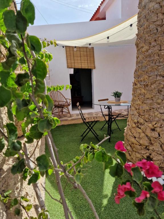 uma vista para o pátio de uma casa com uma mesa e cadeiras em Little Paradise in El Médano em Granadilla de Abona