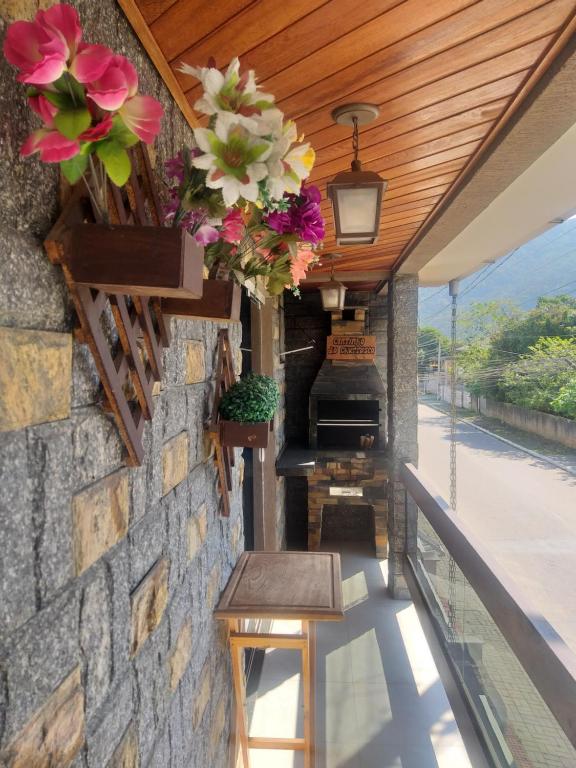 un balcón con flores colgando de un techo de madera en Casa 1 Encanto dos Mares en Itapema