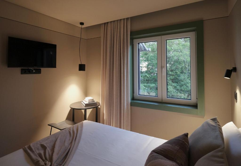 Schlafzimmer mit einem Bett und einem Fenster in der Unterkunft Oporto CoLiving Circunvalação 13250 in Porto
