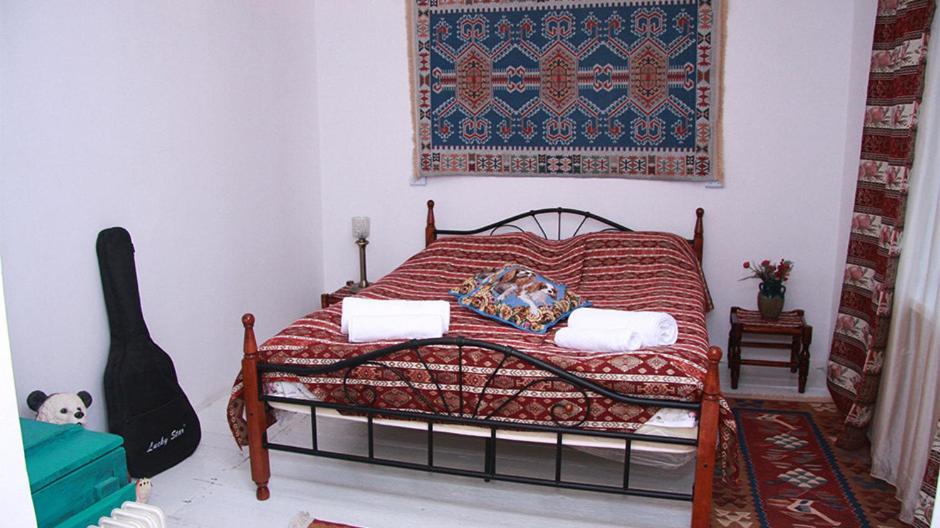 a bedroom with a bed with a red blanket at Pottery House Sanahin in Alaverdi