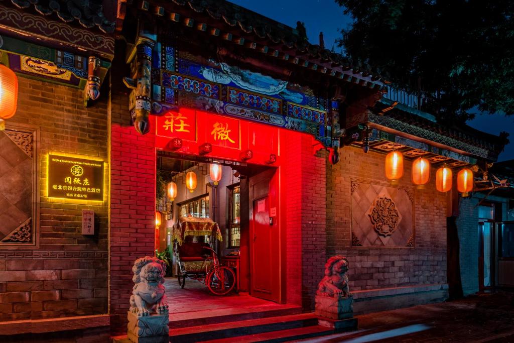 una puerta roja de un edificio con una puerta roja en Beijing Double Happiness Courtyard Hotel, en Beijing