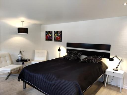 Uma cama ou camas num quarto em Værelser i midtbyen