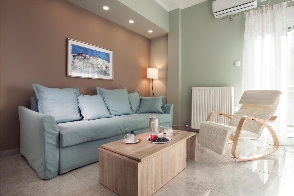 - un salon avec un canapé bleu et une table dans l'établissement Διαμερίσματα στο Δυτικό Μοσχάτο, au Pirée