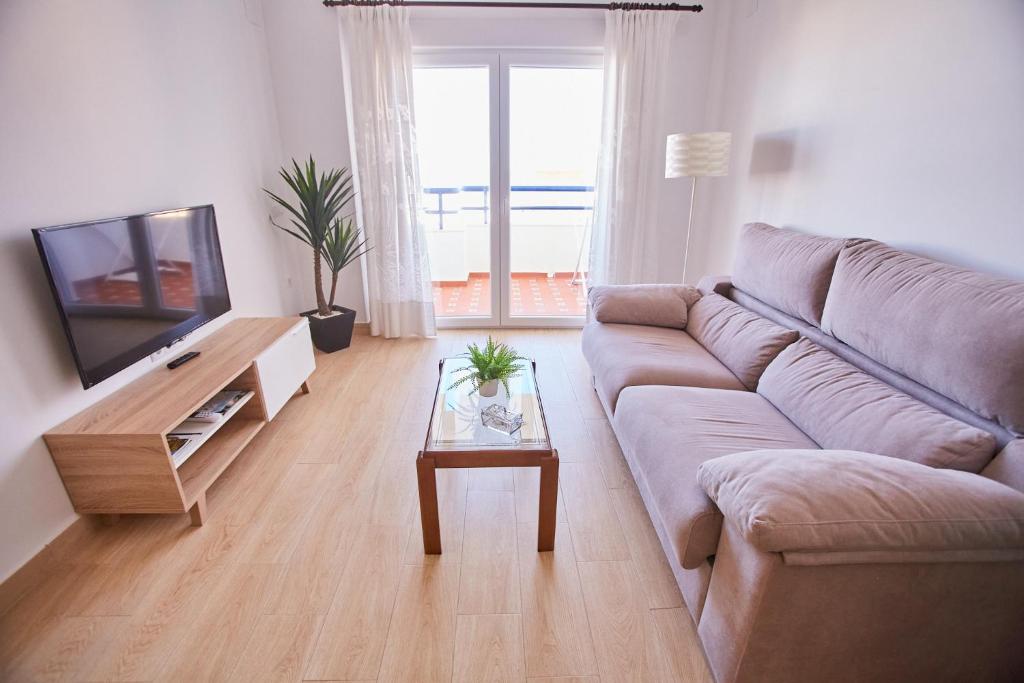 uma sala de estar com um sofá e uma televisão em VistAzul 402 em Lepe