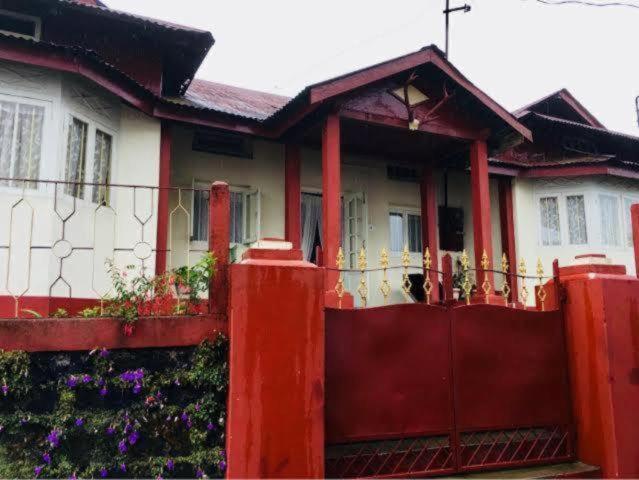 a red fence in front of a house at Odyssey's Pateng Homestay, Cherrapunji in Cherrapunji