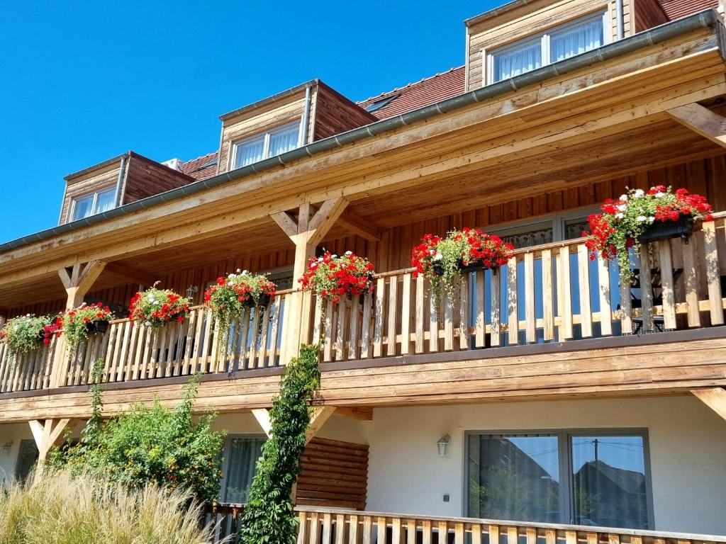 une maison avec des boîtes de fleurs sur le balcon dans l'établissement Hôtel Le Dormeur, à Dorlisheim